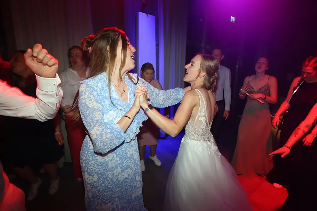 Tanz der Braut auf voller Tanzfläche mit bunter Partybeleuchtung