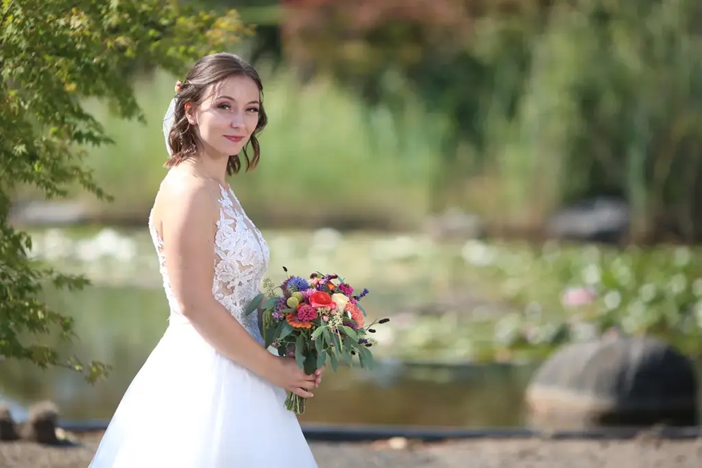 Braut mit Brautstrauß beim Portraitshooting, natürlicher Fotostil