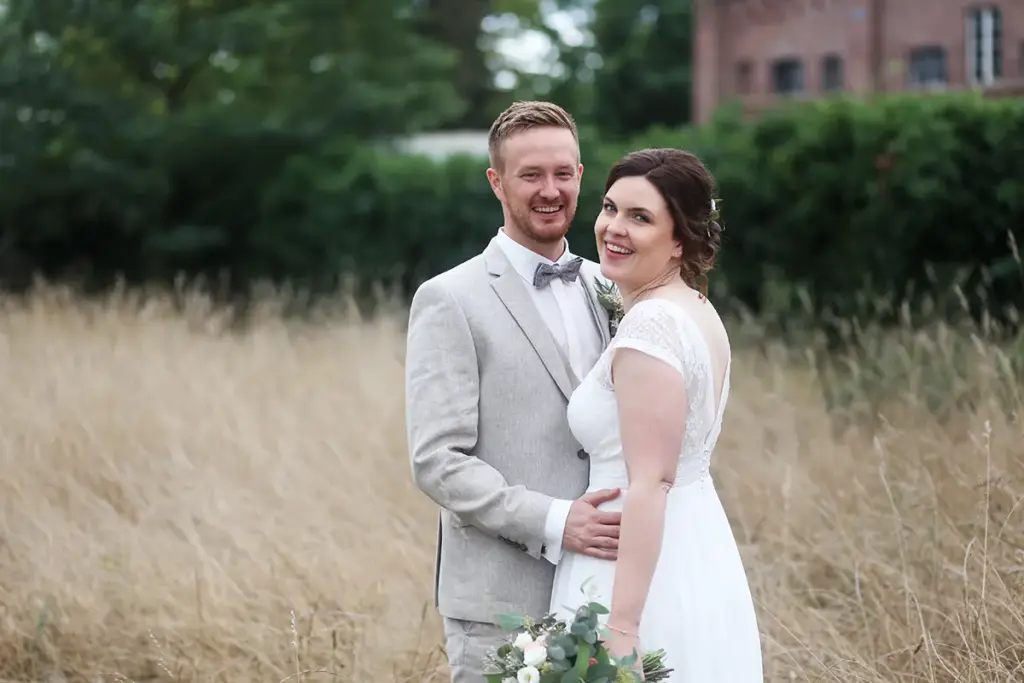 Authentisches Hochzeitsfoto: Lachendes Brautpaar beim Spaziergang, natürlicher Fotostil