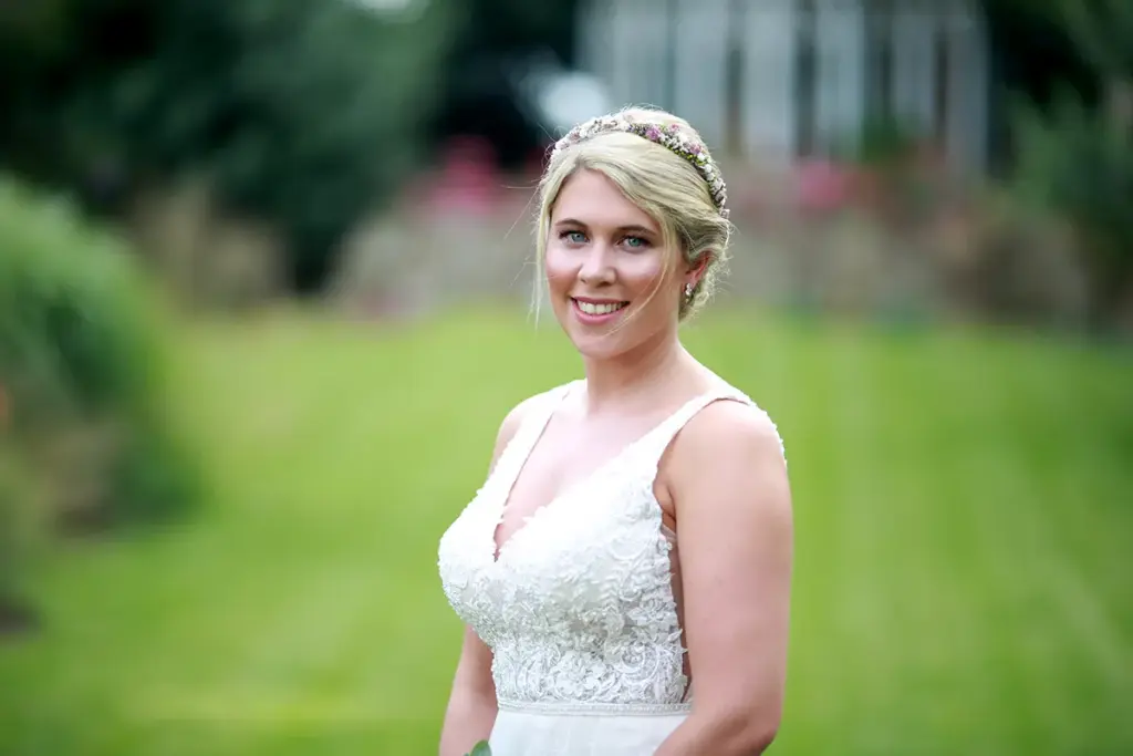 Strahlende Braut im Park mit weichem Bokeh im Hintergrund