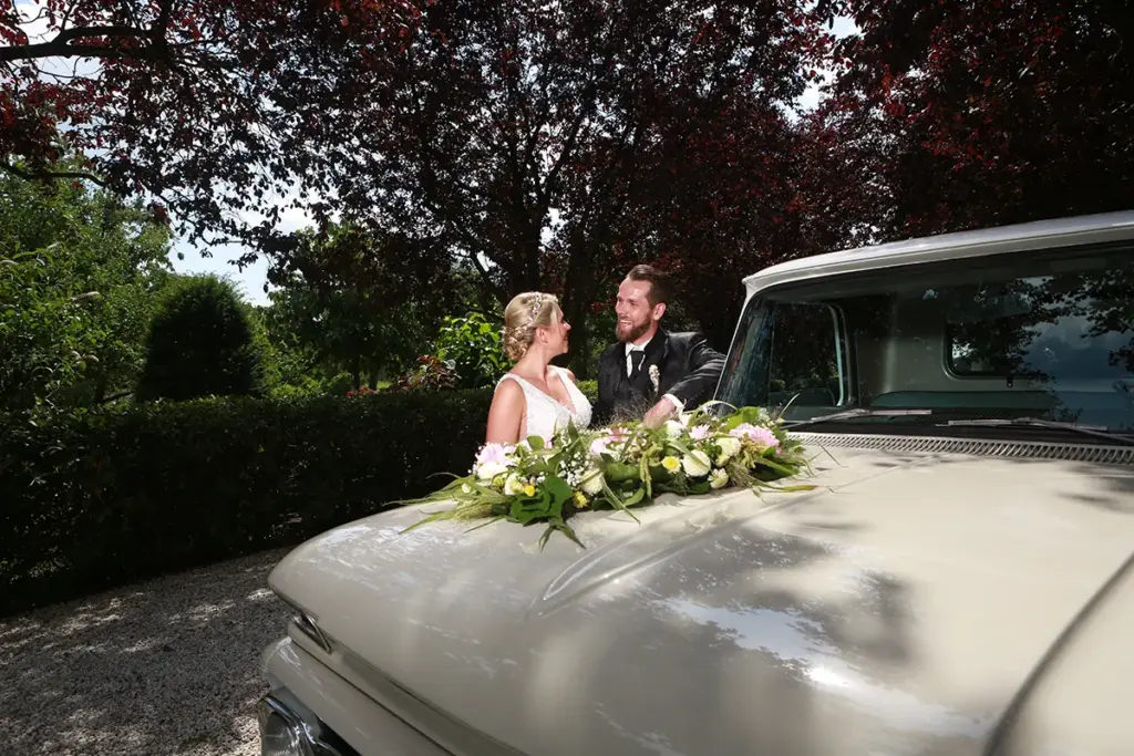 Brautschmuck auf dem Oldtimer mit Brautpaar im Hintergrund beim Brautpaar-Shooting