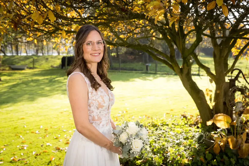 Geblitztes Brautportrait unter einem Baum im Gegenlicht