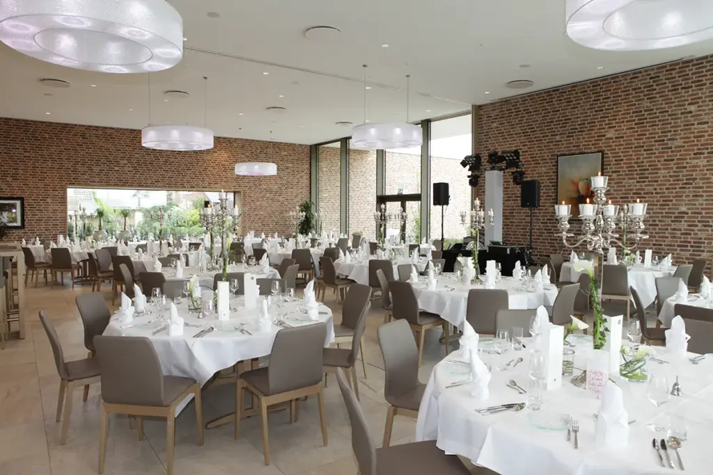 moderner Hochzeitssaal mit rundentischen eleganter Tischdekoration