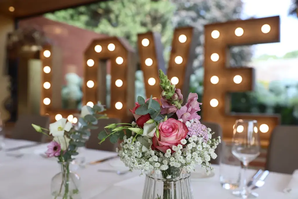 Lechtbuchstaben Love bei Hochzeit mit Brautstrauß