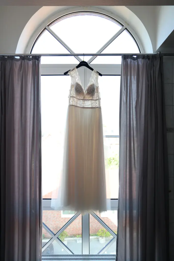 Brautkleid hängt im Fenster Hotel Elbers